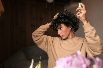 Woman spraying her curly hair