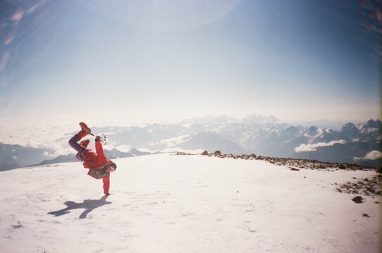 Happy mountaineer showing handstand in mountains