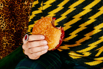man wearing a ring eating a burger