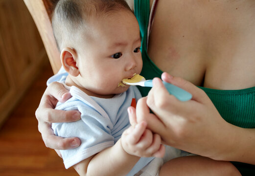Closeup of Asian baby eating complementary food
