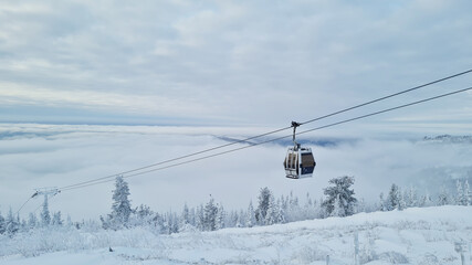 Empty white red closed ski lift cabin no people and white dramatic snowy mountains background. End...