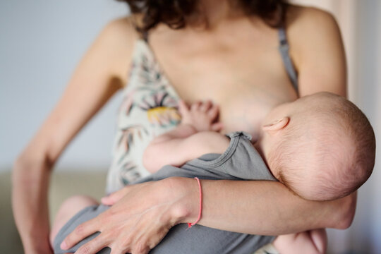 Faceless female feeding with breast