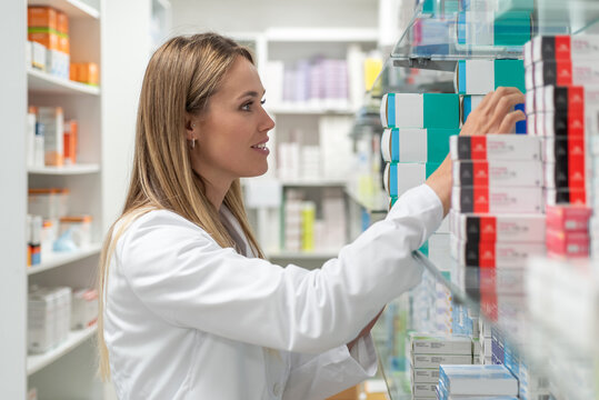 Pharmacist searching drug on shelf