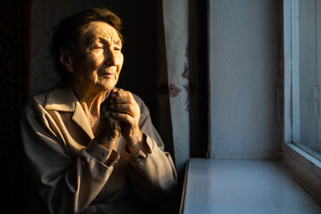 Close up portrait of an old woman praying