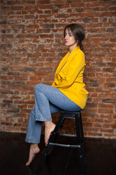   25 - Year - Old Girl Poses In   Fashionable Yellow Jacket And Jeans .