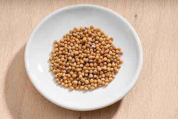 Detailed and large close up shot of mustard seeds on a small plate
