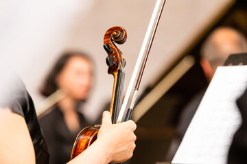 Symphony orchestra on stage, hands playing violin