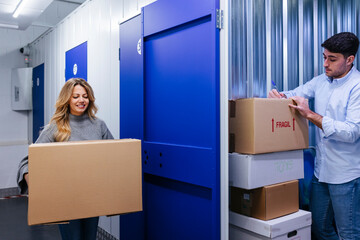Cheerful couple with cardboard boxes in storage room