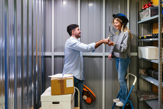 Cheerful couple moving things in a storage room