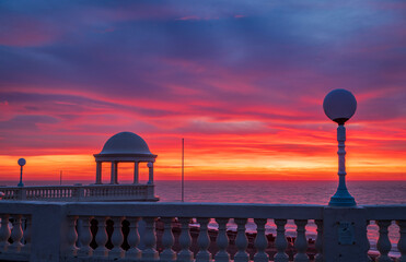 Brilliant red dawn sky over Bexhill Colonnade east Sussex coast south east England UK