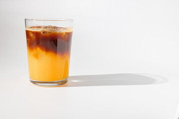 Glass of ice coffee with cream poured over, ice cubes