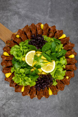 Raw meatballs (cig kofte) on a dark background. Traditional Turkish cuisine delicacies. Top view. Close up