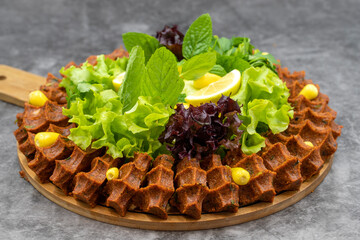 Raw meatballs (cig kofte) on a dark background. Traditional Turkish cuisine delicacies. Horizontal view. Close up
