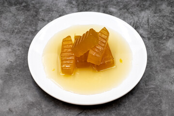 Pumpkin dessert with syrup on dark background. Traditional Mediterranean cuisine delicacies. Turkish Ramadan dessert. Horizontal view. Close up
