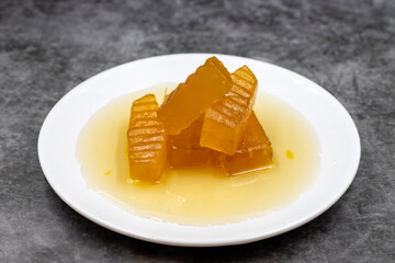 Pumpkin dessert with syrup on dark background. Traditional Mediterranean cuisine delicacies. Turkish Ramadan dessert. Horizontal view. Close up