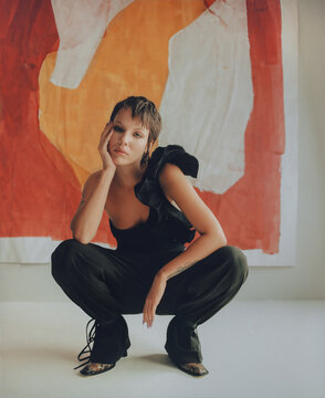 Fashion Top Model In Front Of Abstract Paintings.