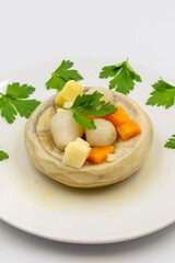 Artichokes with olive oil on white background. Traditional delicious Turkish food; (zeytinyagli enginar). Vertical view. Close up