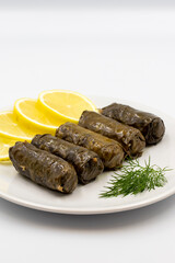 Stuffed grape leaves with olive oil on a white background. Traditional Turkish cuisine delicacies. Delicious dolma (yaprak sarma). Vertical view. Close up