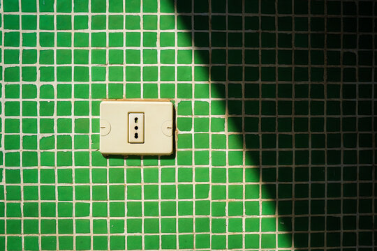 A socket on a green wall.