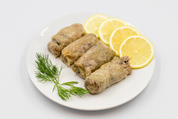 Stuffed cabbage leaves, in a ceramic plate. Vegan cabbage rolls, cooked cabbage leaves, wrapped around a filling of rice, onions and spices. (Lahana sarması) Horizontal view. Close up