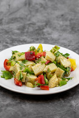 Artichoke salad with olive oil on dark background. Traditional delicious Turkish food; (zeytinyagli enginar). Vertical view. Close up
