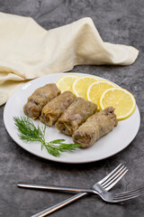 Stuffed cabbage leaves, in a ceramic plate. Vegan cabbage rolls, cooked cabbage leaves, wrapped around a filling of rice, onions and spices. (Lahana sarması) Vertical view. Close up