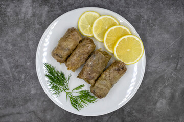 Stuffed cabbage leaves, in a ceramic plate. Vegan cabbage rolls, cooked cabbage leaves, wrapped around a filling of rice, onions and spices. (Lahana sarması) Top view. Close up