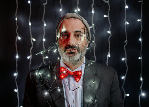 Man in bow tie with Christmas lights on his head 