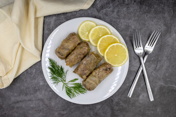 Stuffed cabbage leaves, in a ceramic plate. Vegan cabbage rolls, cooked cabbage leaves, wrapped around a filling of rice, onions and spices. (Lahana sarması) Top view. Close up