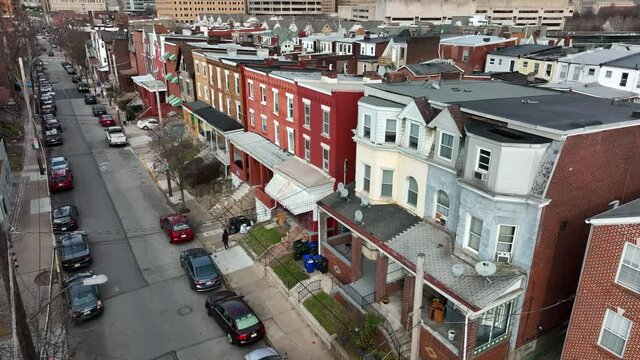 Aerial establishing shot of urban city in USA. Residential housing district. Slow motion of traffic driving and pigeons flying.