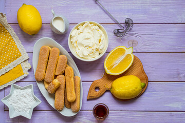 Prepared ingredients for cooking dessert without baking, lemon tiramisu on purple wooden background. Dessert recipes. Valentine's Day.