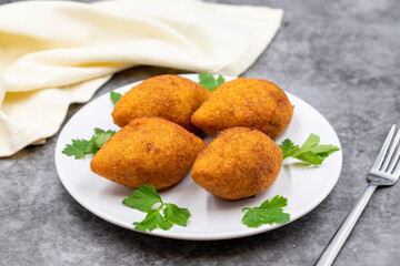 Kibbeh on a dark background. Kibbeh is a popular dish in Middle Eastern cuisine. Stuffed Meatballs Food, Falafel, icli Kofta, Quibe. Horizontal view. Close up
