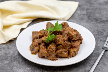 Fried liver cubes on a dark background. Turkish Traditional Food Arnavut Cigeri. Horizontal view. Close up