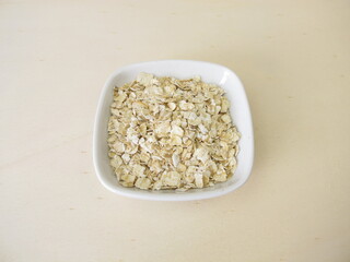Fine rolled oats flakes on a wooden board