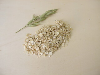 Fine rolled oats flakes on a wooden board