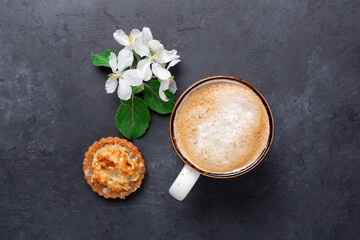 Ceramic mug with coffee, cake and spring flowers on dark stone background. Top view - 478967657