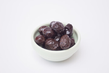 Black olives in a bowl on white background