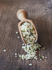 raw peeled hemp seeds, cannabis sativa, on wooden spoon and background. Close up view