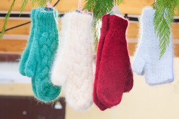 Mittens are in the winter against the background of branches of a Christmas tree. Concept Christmas presents. - 478971893