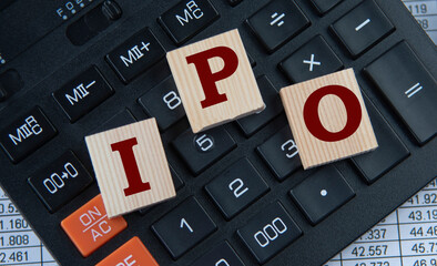 IPO - acronym on wooden cubes on the background of a calculator