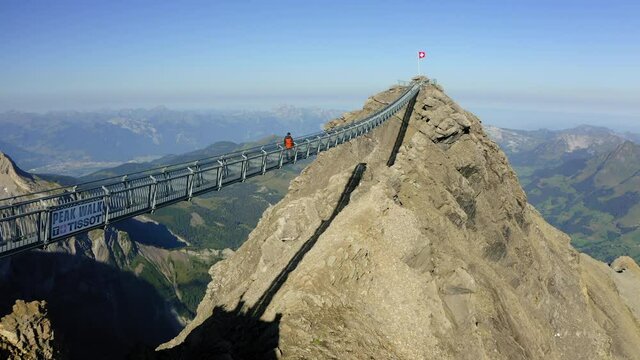 Aerial Forward Shot Of Male Tourist Walking On Peak Walk By Tissot During Vacation - Vaud, Switzerland