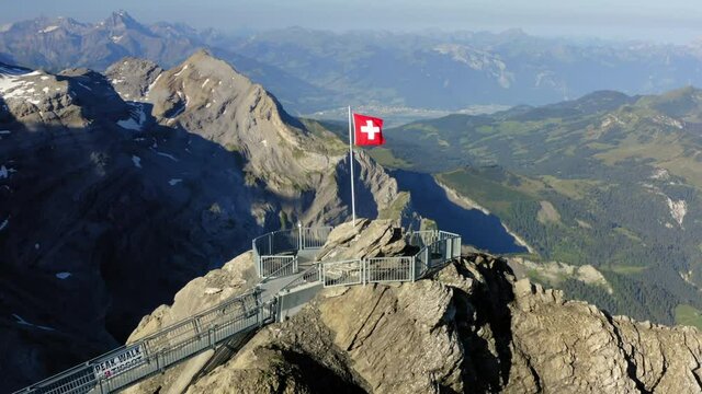 Aerial Panning Flag Of Switzerland On Mountain Top At Observation Point During Sunny Day - Vaud, Switzerland