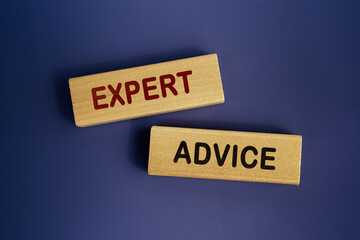 The words 'Expert advice' is written on a wooden blocks on a dark blue background. Business concept