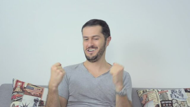 Man sitted doing silly challenge trick with a cookie and then celebrating happy