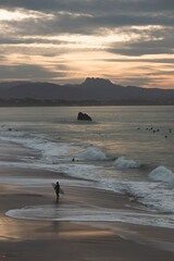 Surfer silhouette sunset in Bidart with a mountain layouts in the background- Les landes - France