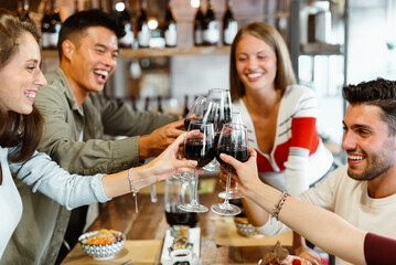 Diverse group of multicultural friends celebrating in restaurant