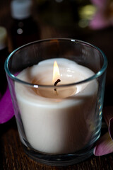 burning aroma candle on a dark background, components of spa treatments, closeup