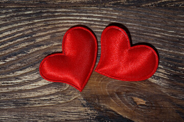 two red hearts on a dark wooden background, closeup