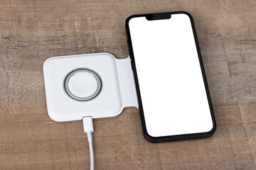 Smartphone on wireless charging on the table. Smartphone is being charged on wireless charging...