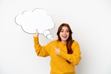 Young redhead woman isolated on white background holding a thinking speech bubble with surprised expression